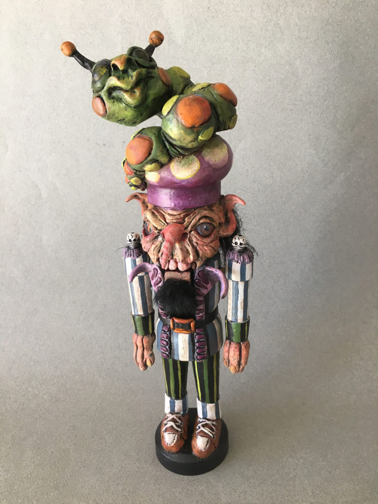 </br><p align="left"><strong><em>Madhatter with Caterpillar Nutcracker</em></strong></br>12" tall</br>Mixed media</br>$170</br><strong><a href="https://checkout.square.site/buy/JV56XSRUVJ2FGIDGMBPYDCO7">PURCHASE</a></strong></p><br>